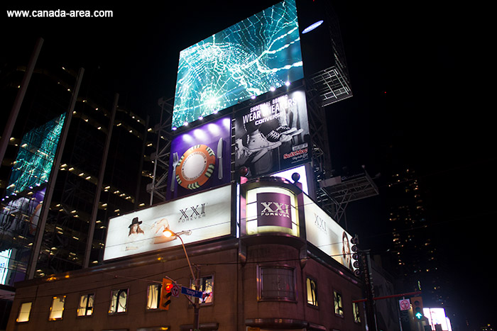 Экраны с рекламой освещают улицы ночью